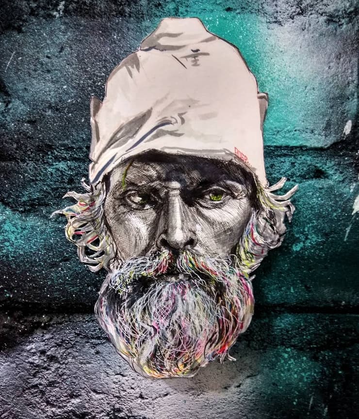 Bearded man in white cap, teal brick wall