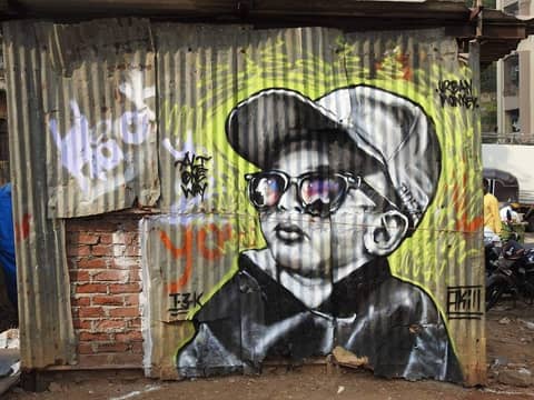 Kid with sunglasses, tin-sheet wall, Marol, Mumbai (hashtags)