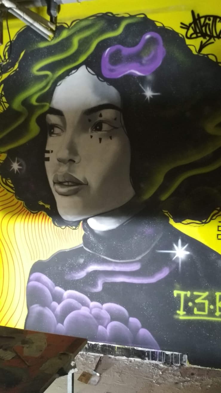 Curly woman on yellow wall, T3K