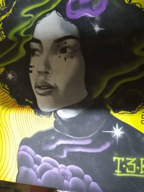 Curly woman on yellow wall, T3K